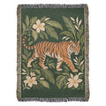 Tiger Botanical woven cotton blanket shown full front: a striding orange tiger among cream blossoms and green leaves on deep green, with fringe.