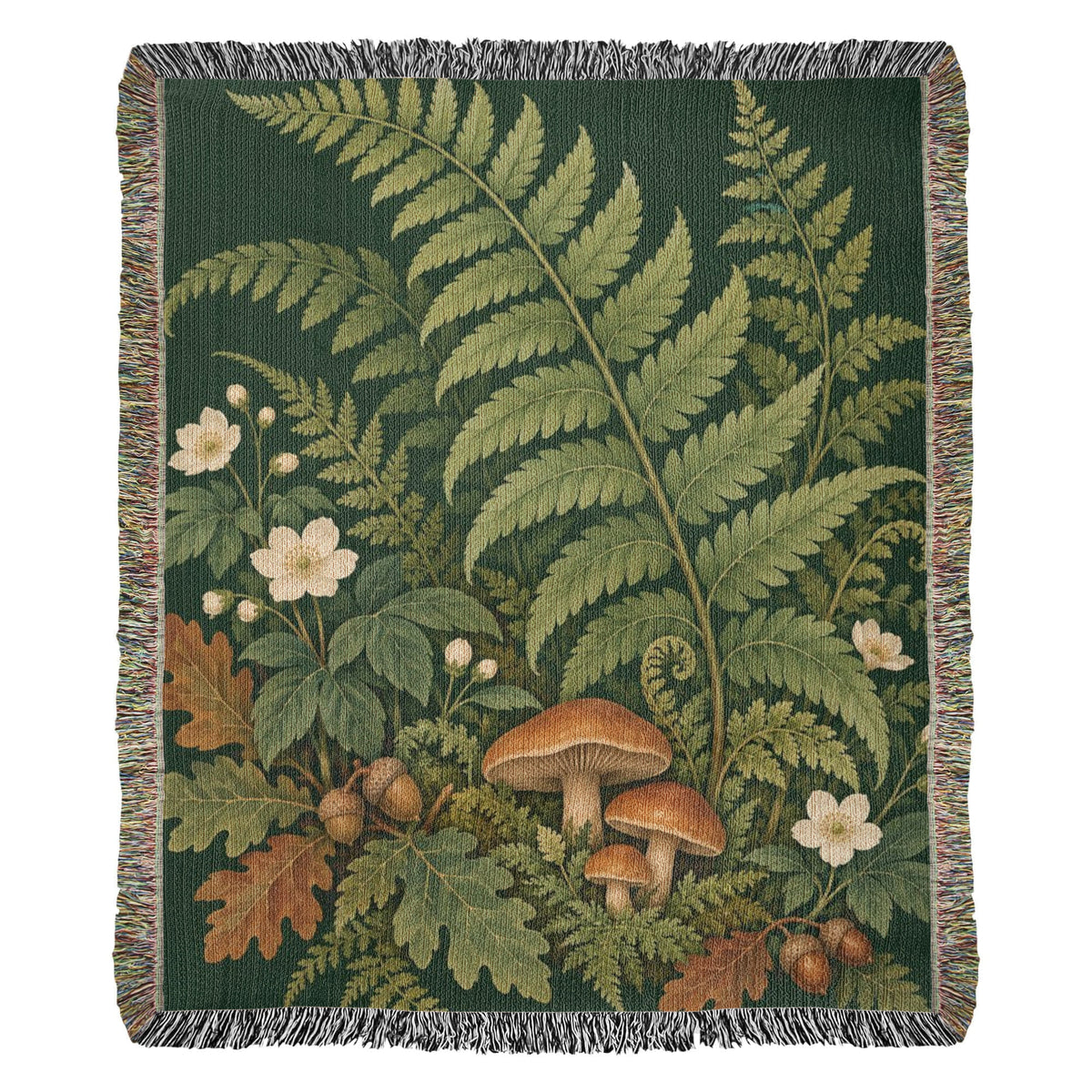 Woodland Garden woven cotton blanket shown full front on a white background: tall green ferns, white flowers, mushrooms and autumn leaves on deep green, with fringed edges.
