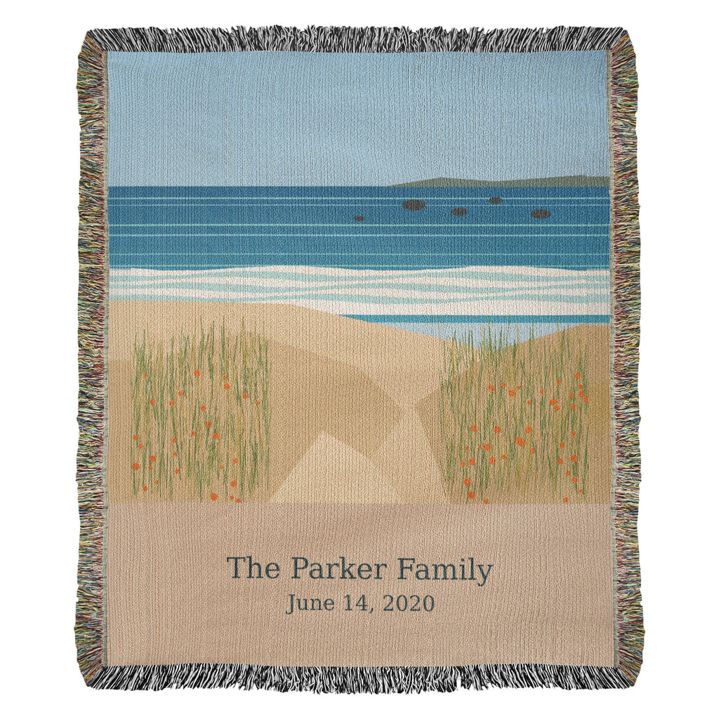 Coastal personalized woven cotton blanket shown full front: sea, white surf and dune grass with "The Parker Family" and June 14, 2020 woven on the sand-coloured panel.