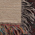 Corner close-up of the Coastal woven cotton blanket showing the cream cotton weave, the multicolour bottom fringe and the black-and-white side fringe.