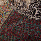 The Coastal woven cotton blanket folded back at the corner to show the reverse weave and the colourful fringe along the hem.