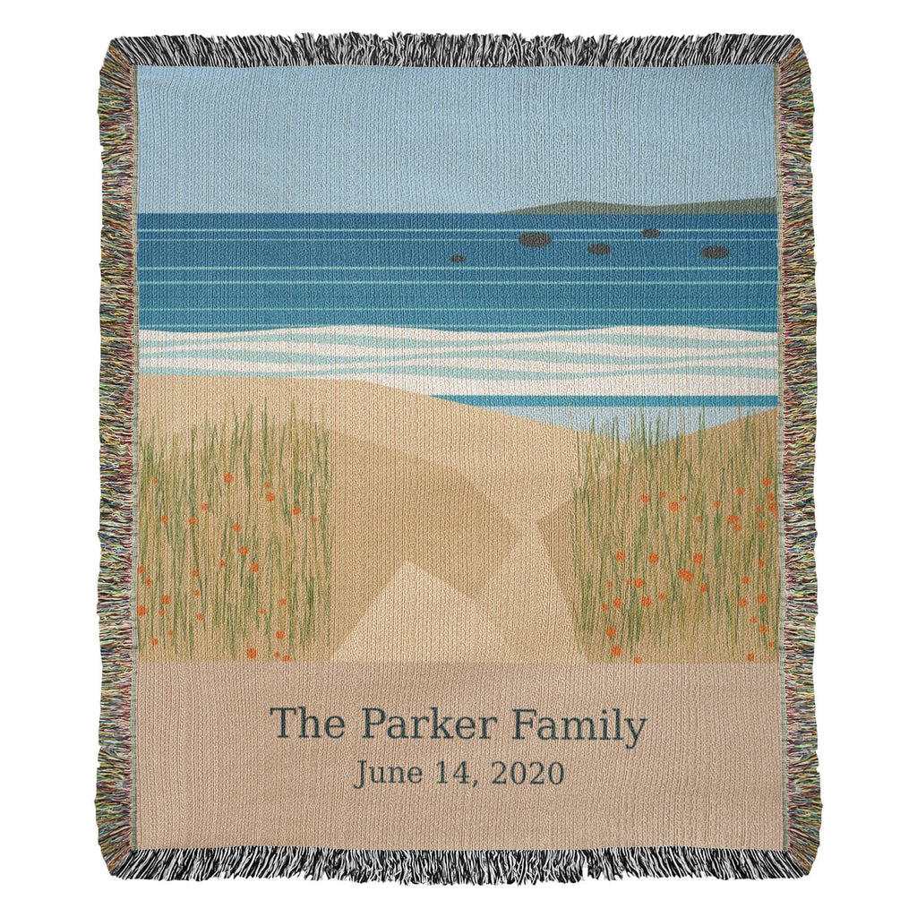 Coastal personalized woven cotton blanket, 50 by 60 inches, shown full front: sea, white surf and dune grass with "The Parker Family" and June 14, 2020 woven on the sand-coloured panel.