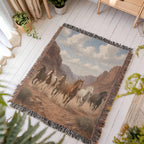 Western horse woven throw spread on a white wood floor with plants, red-rock canyon herd scene and fringed edges