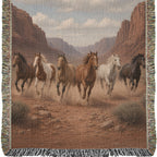 Close-up of the western horse woven throw: six painted horses running through dust in a red-rock canyon, woven texture and fringe