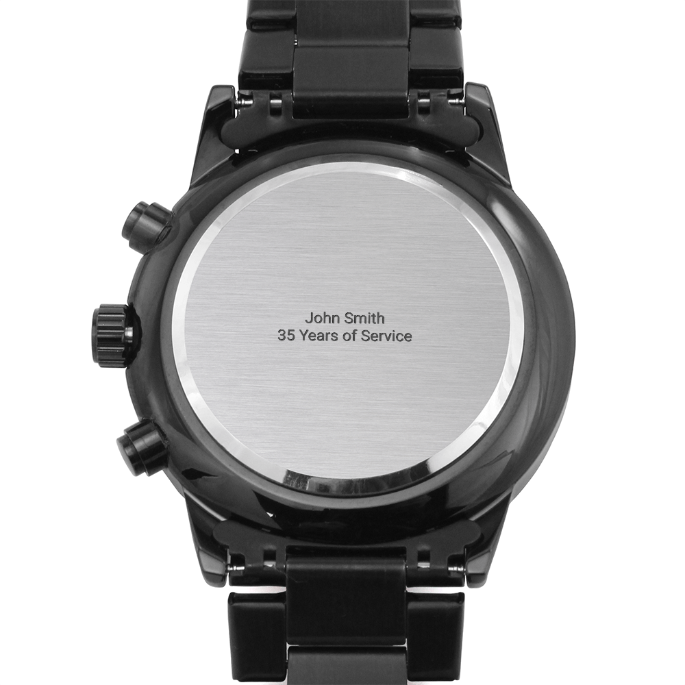 Back of a black chronograph watch with brushed steel caseback on a white background, caseback engraved "John Smith 35 Years of Service"