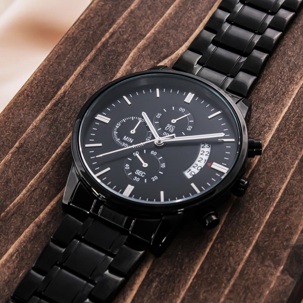 Black chronograph watch with a black metal bracelet on dark wood planks