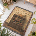 Library cat woven throw: orange tabby folk art spread on a white porch floor beside potted plants