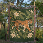 Tiger Botanical woven cotton blanket hung on an outdoor line among trees, the whole tiger and botanical design in view with fringed edges.