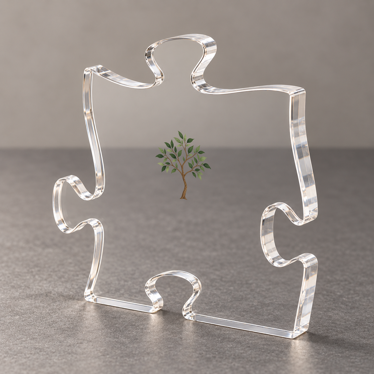 Angled view of the acrylic puzzle plaque showing its thick polished edge and sapling design on a gray surface.