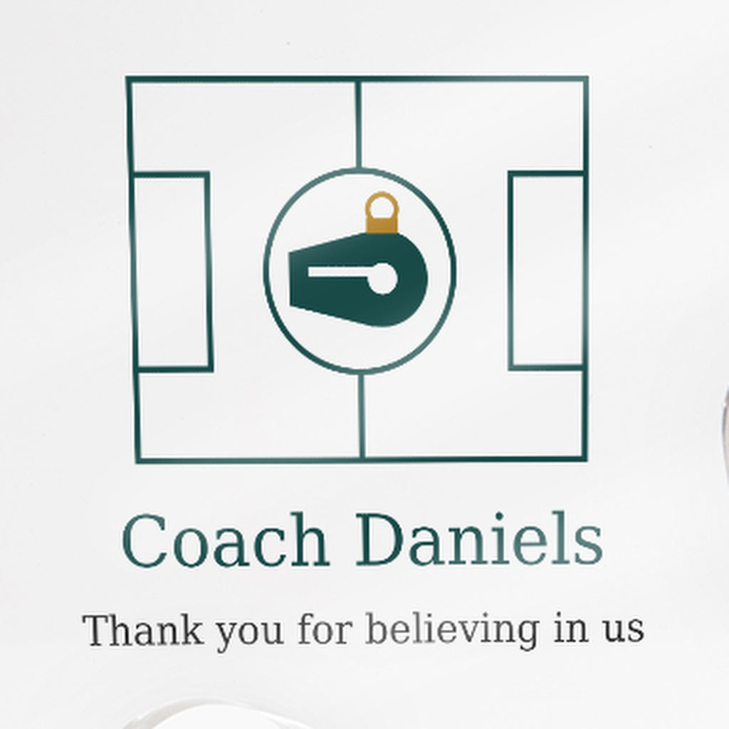 Close-up of the printed text on the clear acrylic puzzle-piece coach plaque reading "Coach Daniels" and "Thank you for believing in us"