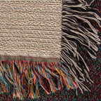 Corner close-up of the Lake House woven cotton blanket showing the cream cotton weave, the multicolour bottom fringe and the black-and-white side fringe.