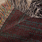 The Lake House woven cotton blanket folded back at the corner to show the reverse weave and the colourful fringe along the hem.