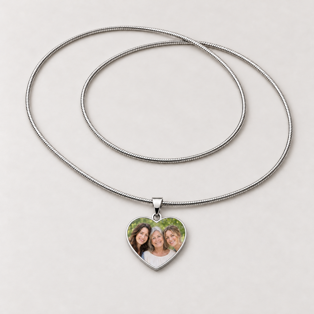 Steel heart photo necklace with a family photo of three smiling women on the pendant and a full snake chain