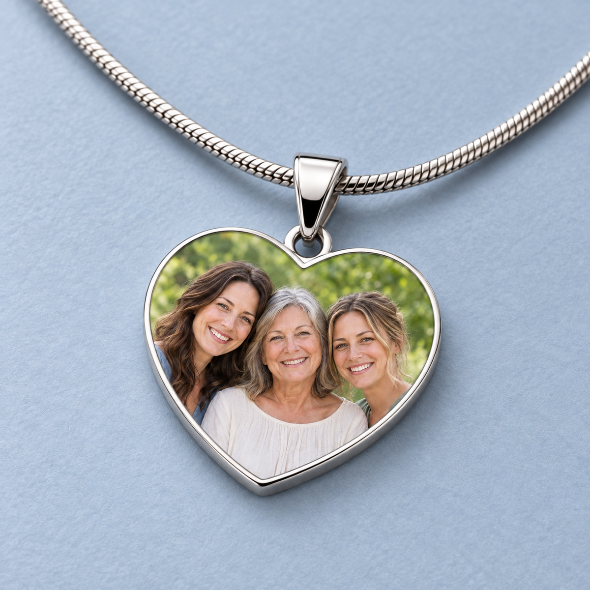 Close view of the family photo, polished silver-tone heart rim, tapered bail and snake chain