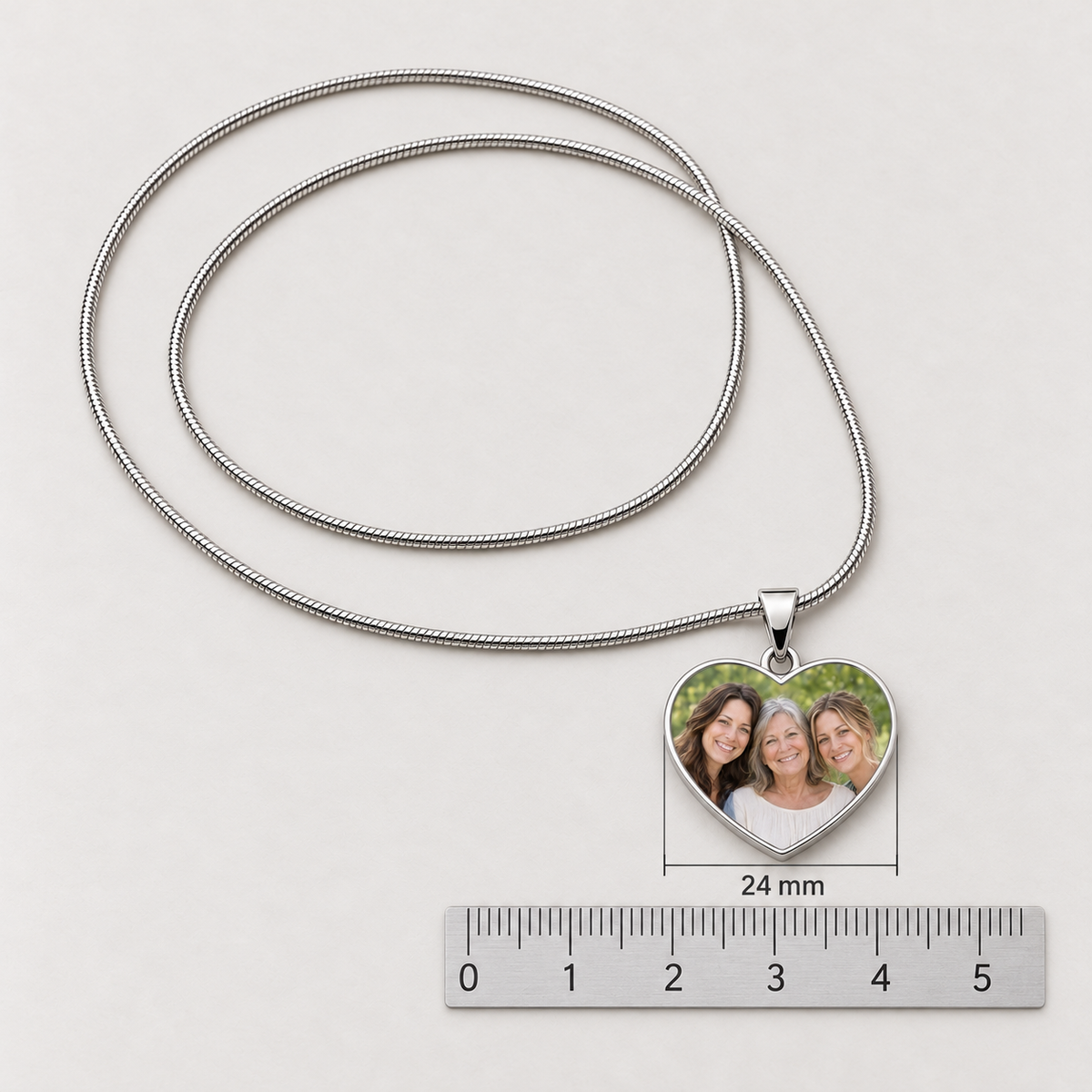 Photo heart pendant measuring 24 mm wide, shown above a metric ruler