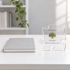 Clear acrylic puzzle-piece plaque with an oak tree, Dr. Morgan and a thank-you message, beside a notebook on a white desk