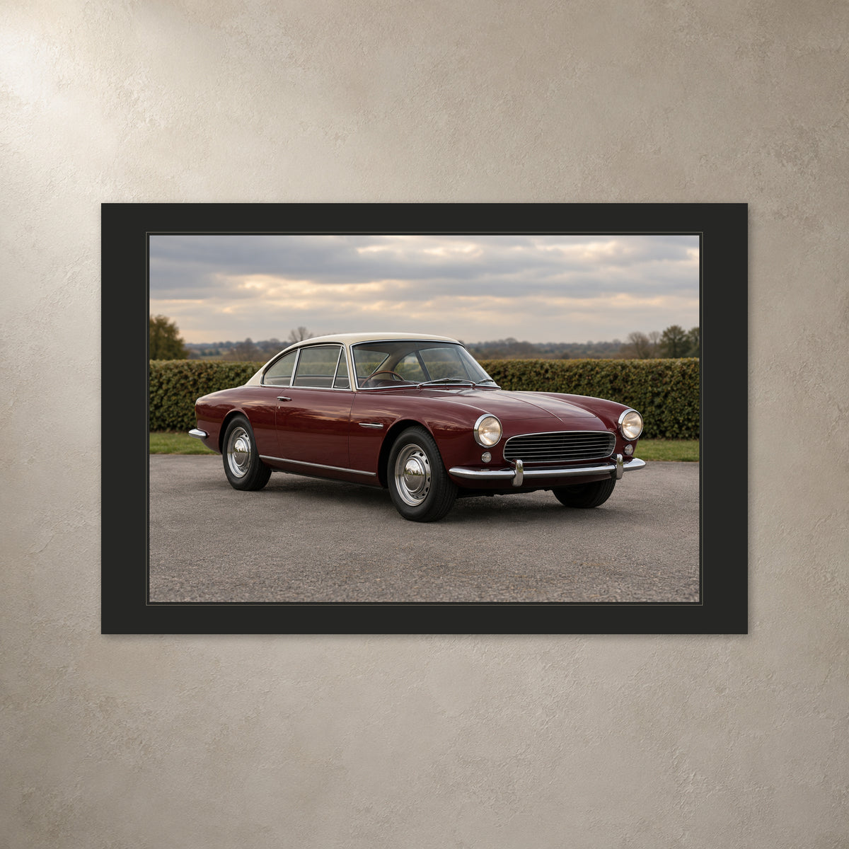 Classic car photo canvas with a charcoal printed border, shown from the front on a light plaster wall.