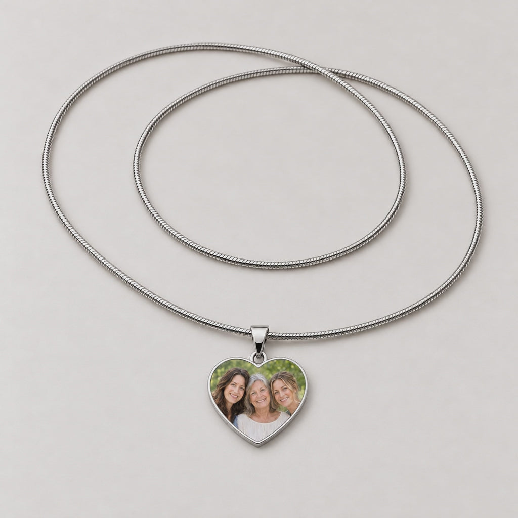 Video of a silver heart pendant necklace with a photo of three women, plus a plain polished heart pendant.