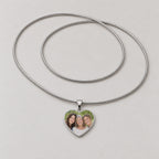Video of a silver heart pendant necklace with a photo of three women, plus a plain polished heart pendant.