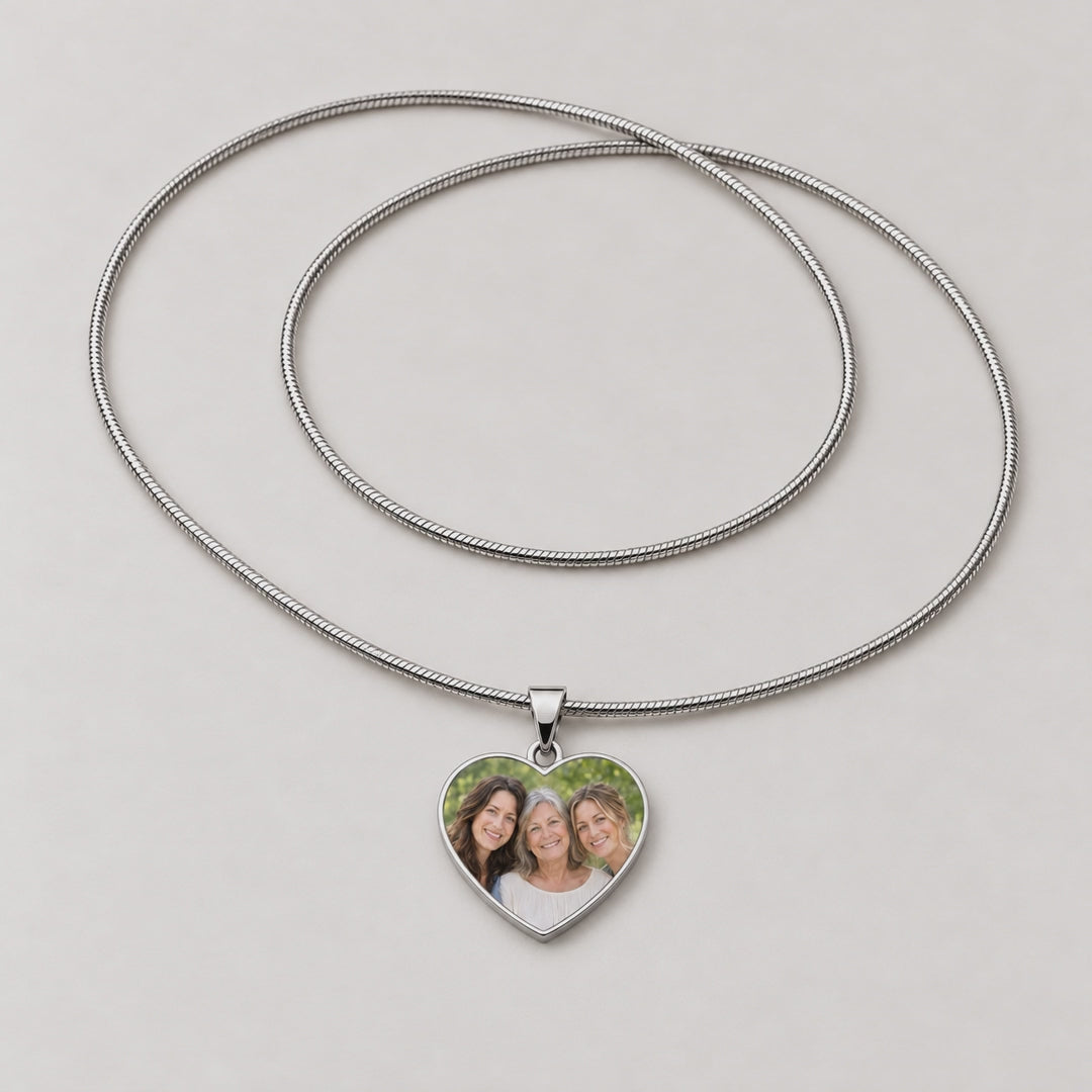 Video of a silver heart pendant necklace with a photo of three women, plus a plain polished heart pendant.